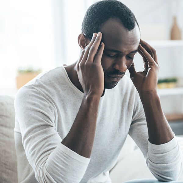 a man in pain holding his head