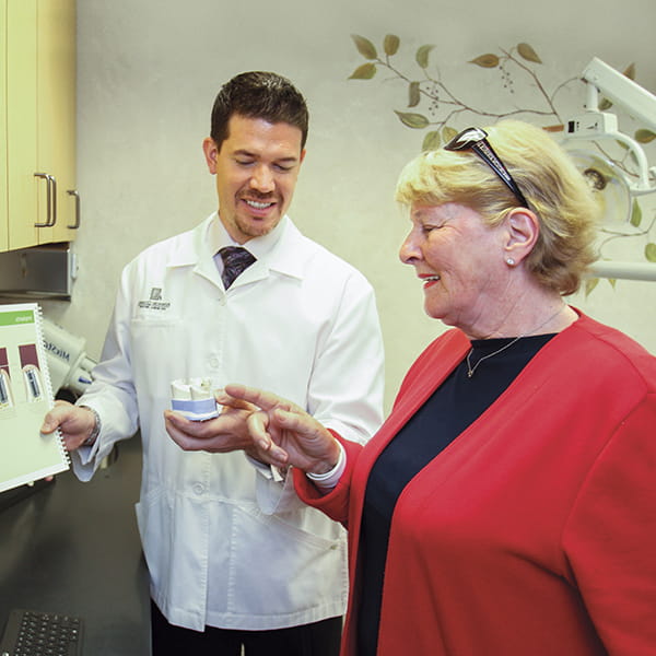 Dr.Nosti is showing a picture and discussing a procedure to a lady patien