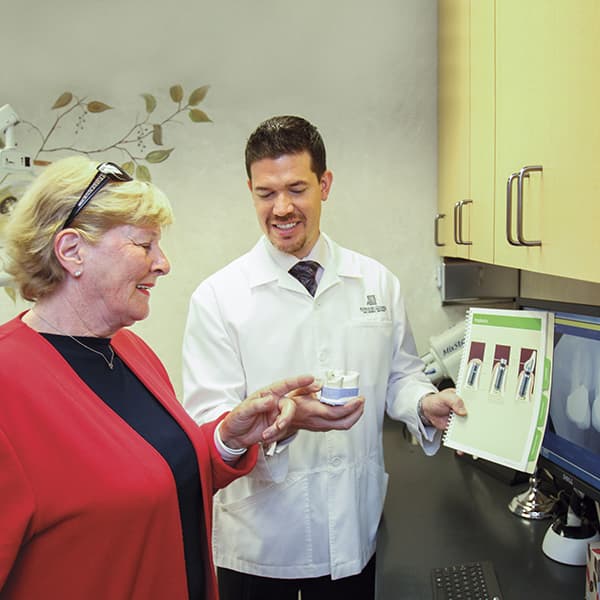 Presenting Dental Procedure Dr.Nosti is showing a picture of dental procedure to a lady patient