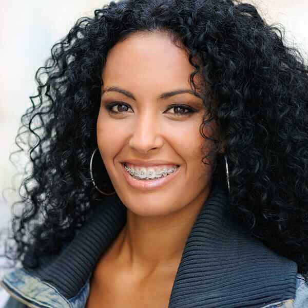 Lady with big curls A smiling lady with big curls and big earrings is wearing braces
