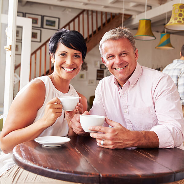 Couple holding cup A couple is smiling while holding on a white cup
