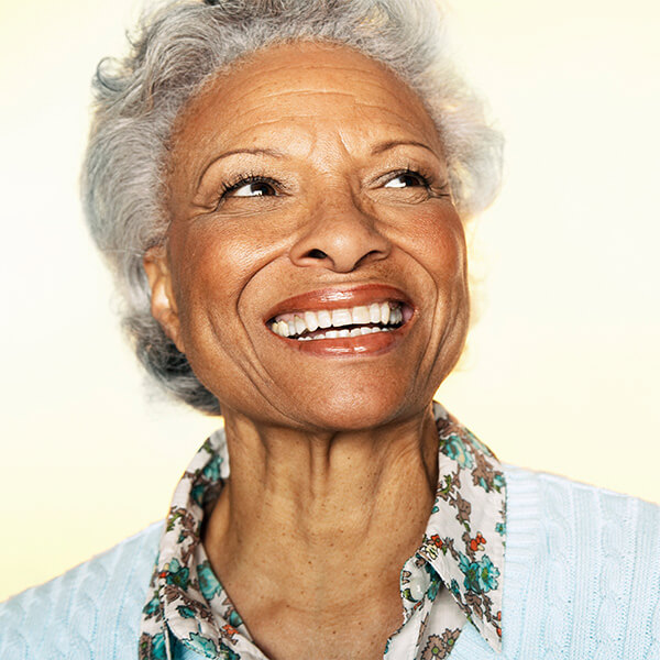 Lady holding a tablet A lady with short curly hair smiling on a light background